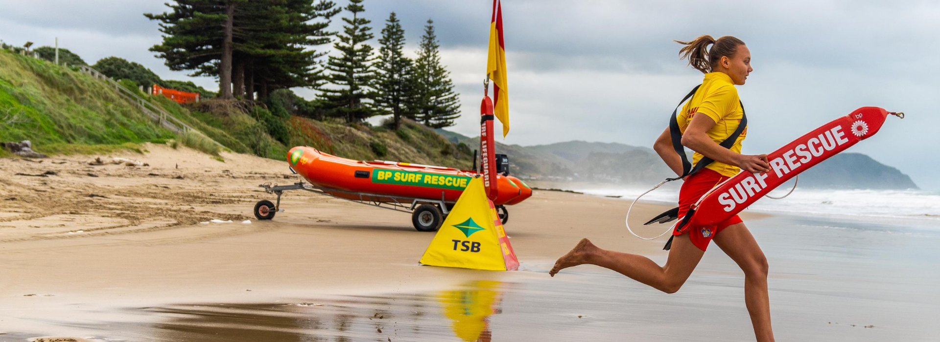 Female Lifeguard Running into Water with Rescue Tube 2